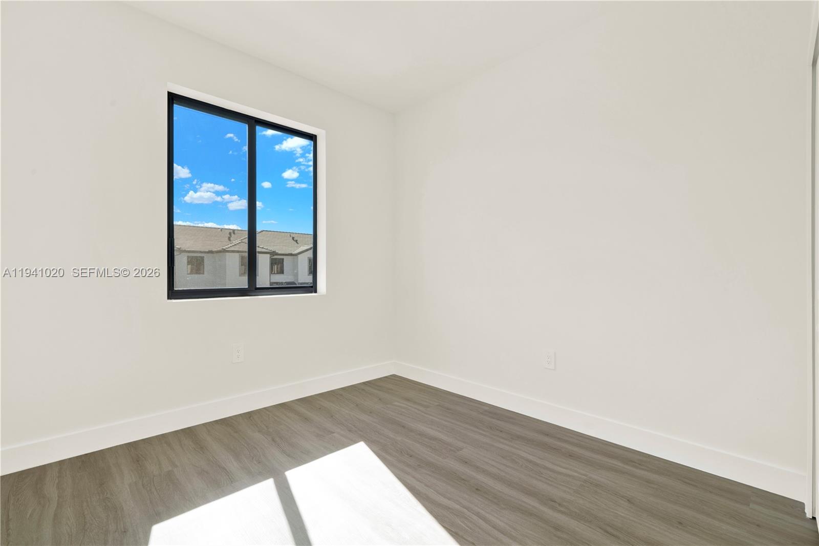 18981 Southwest 344th Terrace, Unit 18981 Homestead, FL 33034 - Photo 29 of 34 a view of an empty room with wooden floor and a window