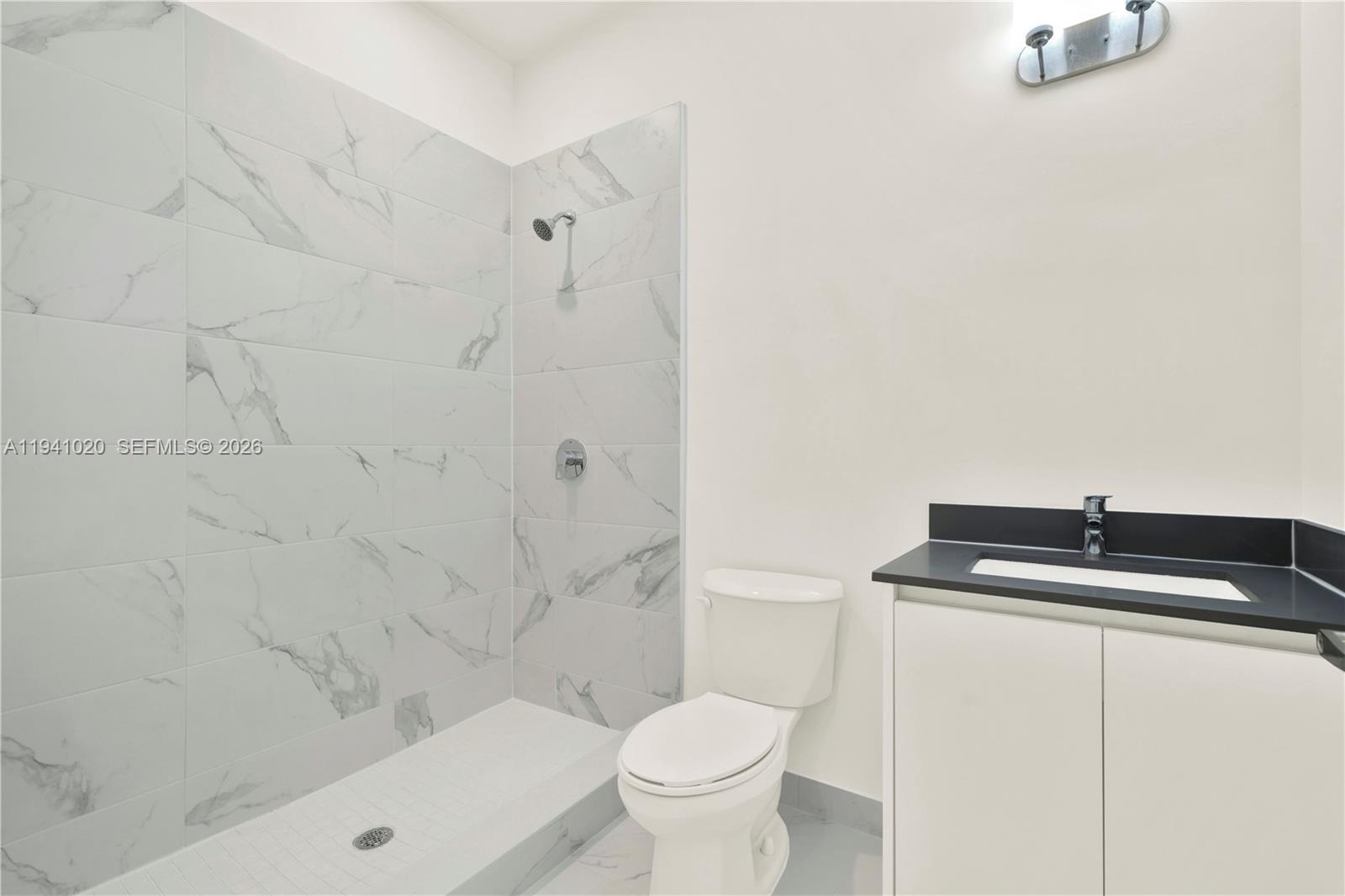 18981 Southwest 344th Terrace, Unit 18981 Homestead, FL 33034 - Photo 32 of 34 a bathroom with a granite countertop sink and a toilet