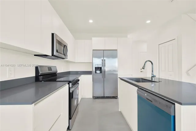 a kitchen with stainless steel appliances granite countertop a sink refrigerator and microwave