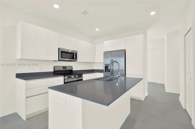 a view of kitchen with kitchen island microwave and view living room