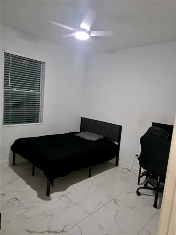 a bedroom with a bed a desk and chair