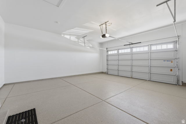 2559 West Aurora Avenue Mapleton, UT 84664 - Photo 55 of 60 Two-car garage featuring an automatic overhead door with upper window panels, epoxy-coated concrete flooring, and a floor drain