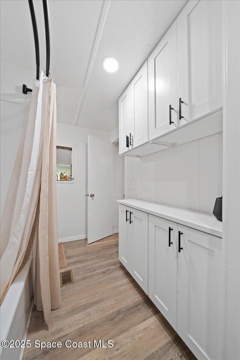 6983 Chestnut Drive Cocoa, FL 32927 - Photo 16 of 28 a view of a kitchen with white cabinets and wooden floor