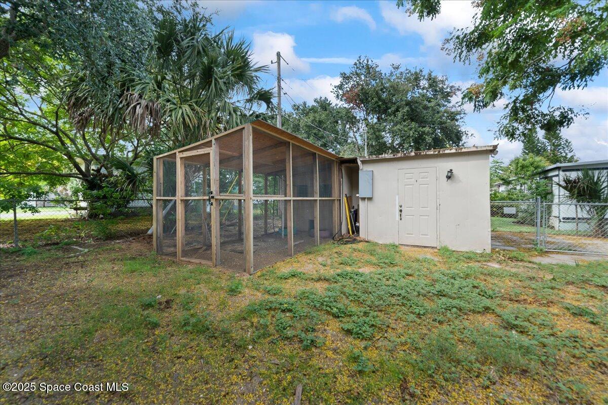 6983 Chestnut Drive Cocoa, FL 32927 - Photo 27 of 28 a view of a wooden house with a yard and large trees