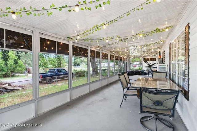 a dining room with furniture and a floor to ceiling window
