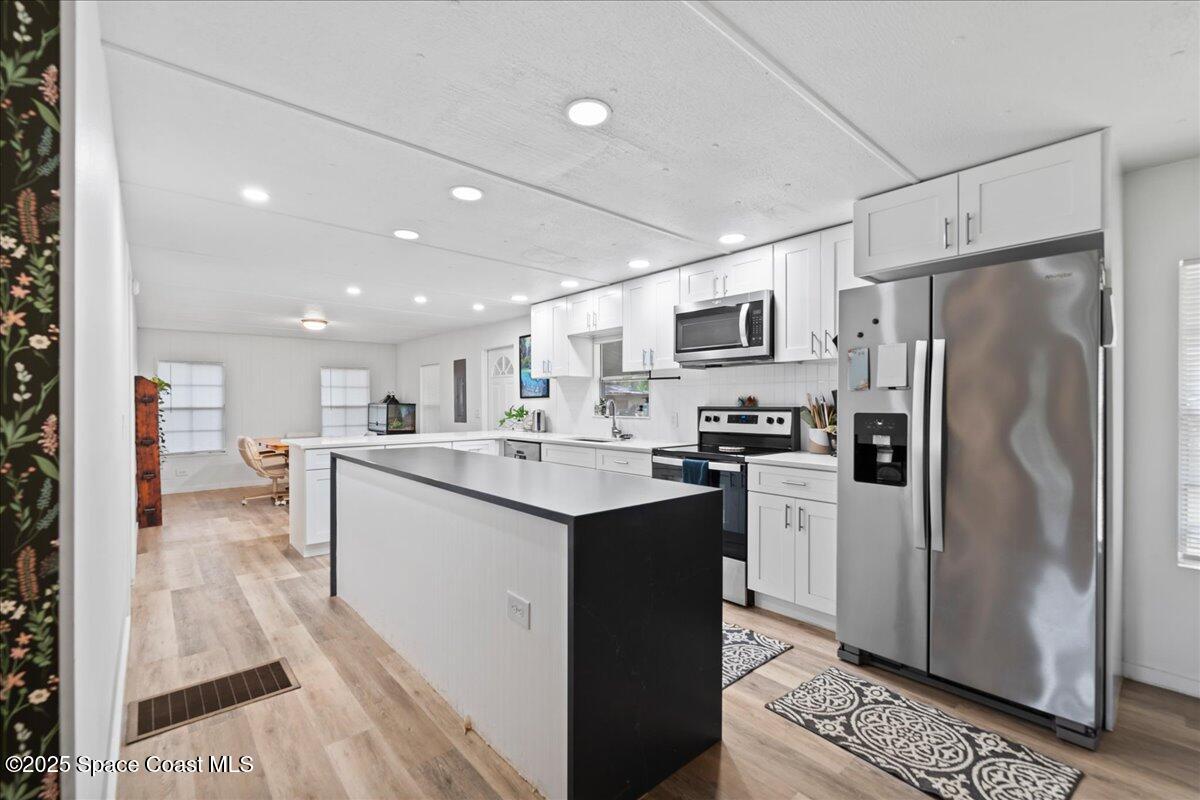 6983 Chestnut Drive Cocoa, FL 32927 - Photo 9 of 28 a kitchen with stainless steel appliances granite countertop a refrigerator sink and microwave