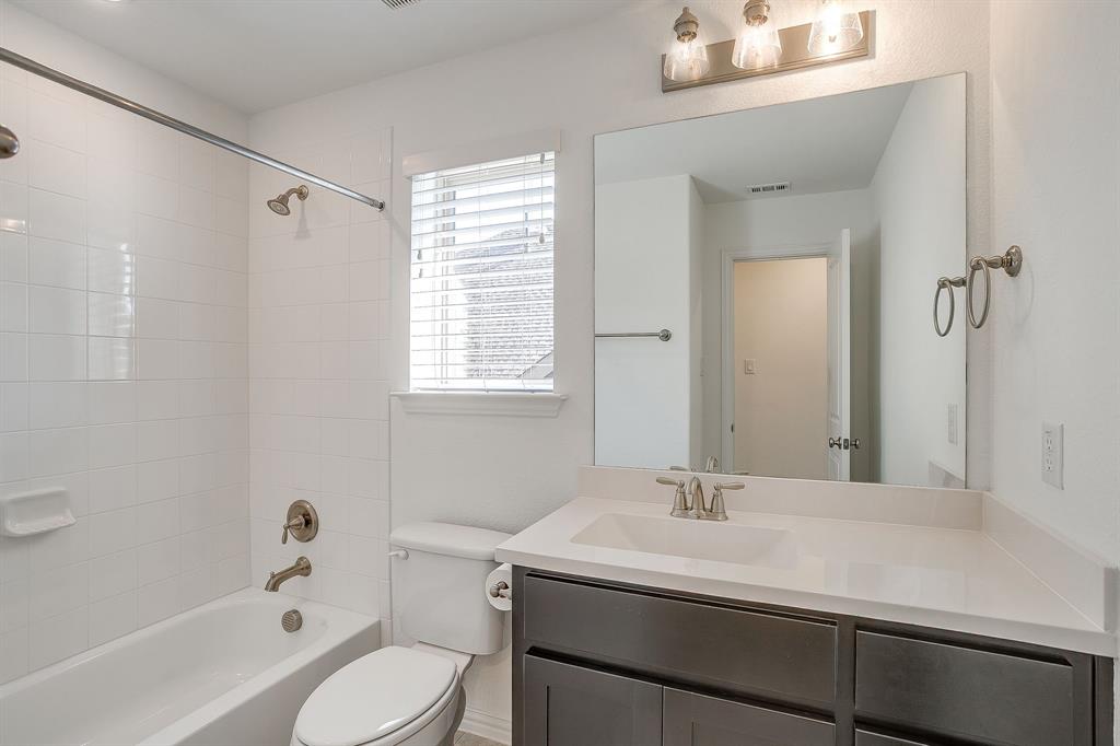 14328 Capridge Road Fort Worth, TX 76008 - Photo 24 of 40 a bathroom with a granite countertop sink toilet a mirror and shower