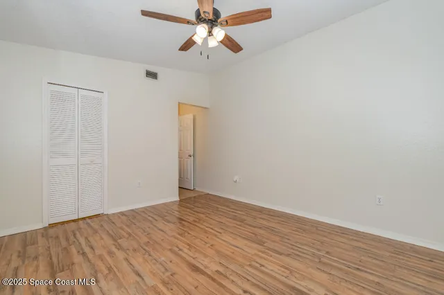 a view of an empty room with wooden floor