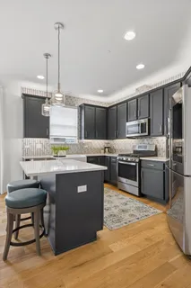 a kitchen with kitchen island granite countertop wooden cabinets and stainless steel appliances
