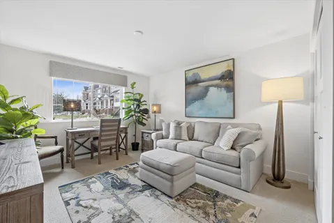 a living room with furniture a lamp paintings and a window