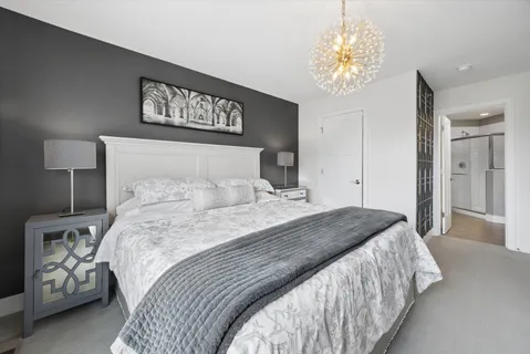 a bedroom with a large bed and a chandelier