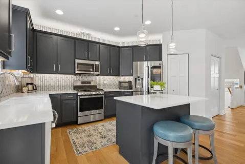 a kitchen with kitchen island granite countertop stainless steel appliances cabinets a sink and a center island