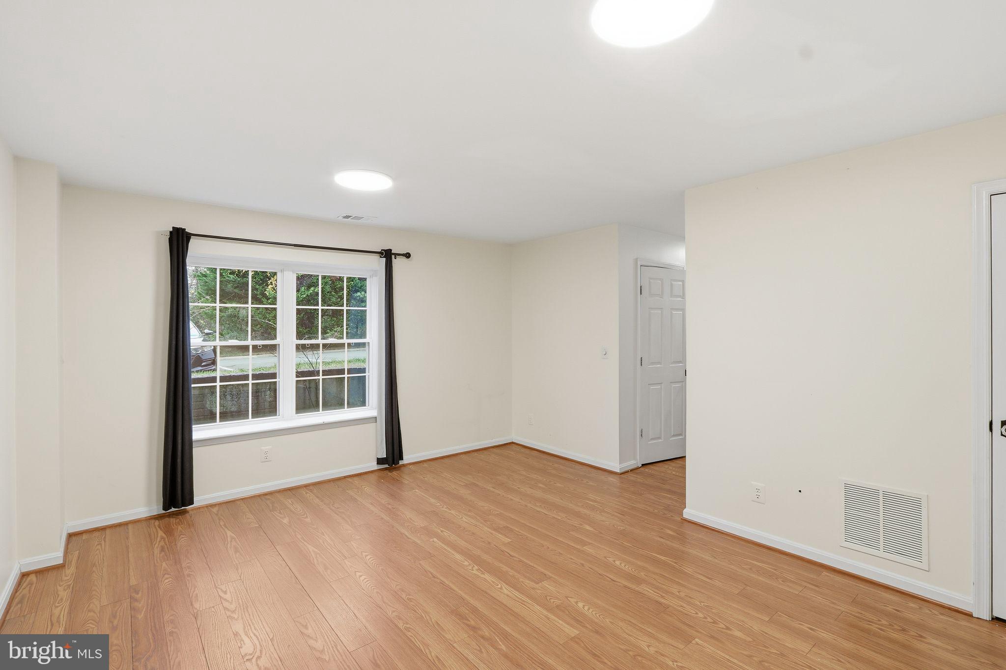 15663 Viewpoint Circle Dumfries, VA 22025 - Photo 11 of 30 a view of an empty room with wooden floor and a window