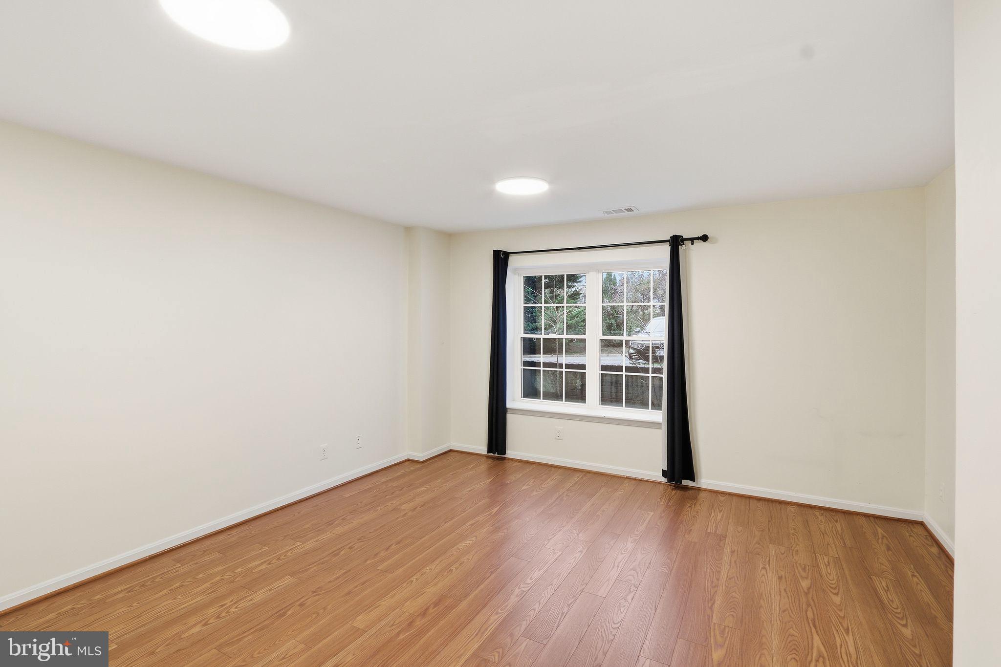 15663 Viewpoint Circle Dumfries, VA 22025 - Photo 12 of 30 a view of an empty room with wooden floor and a window