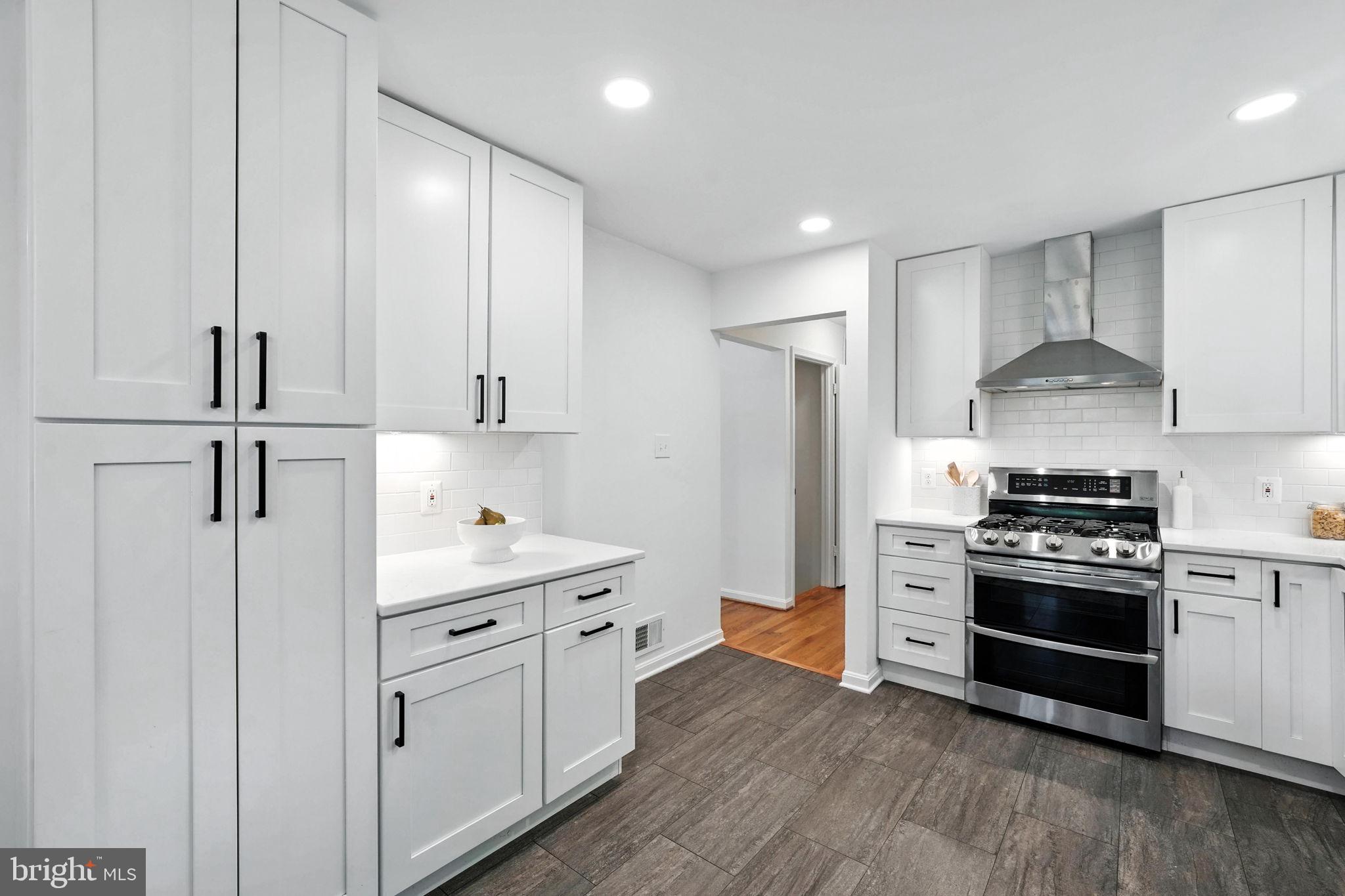 6910 Barnack Drive Springfield, VA 22152 - Photo 11 of 44 a kitchen with white cabinets and stainless steel appliances
