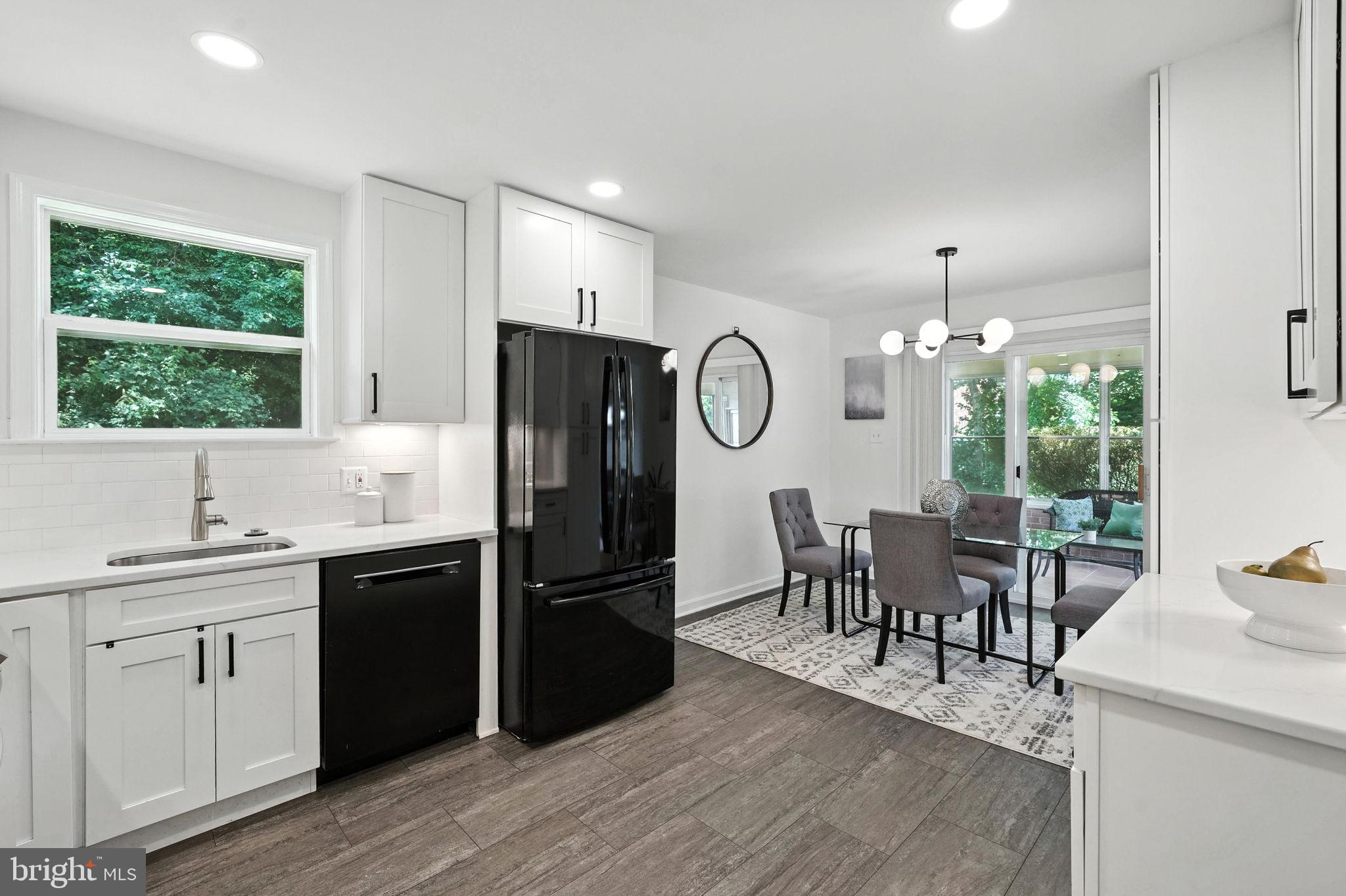 6910 Barnack Drive Springfield, VA 22152 - Photo 13 of 44 a kitchen with a table chairs refrigerator and cabinets