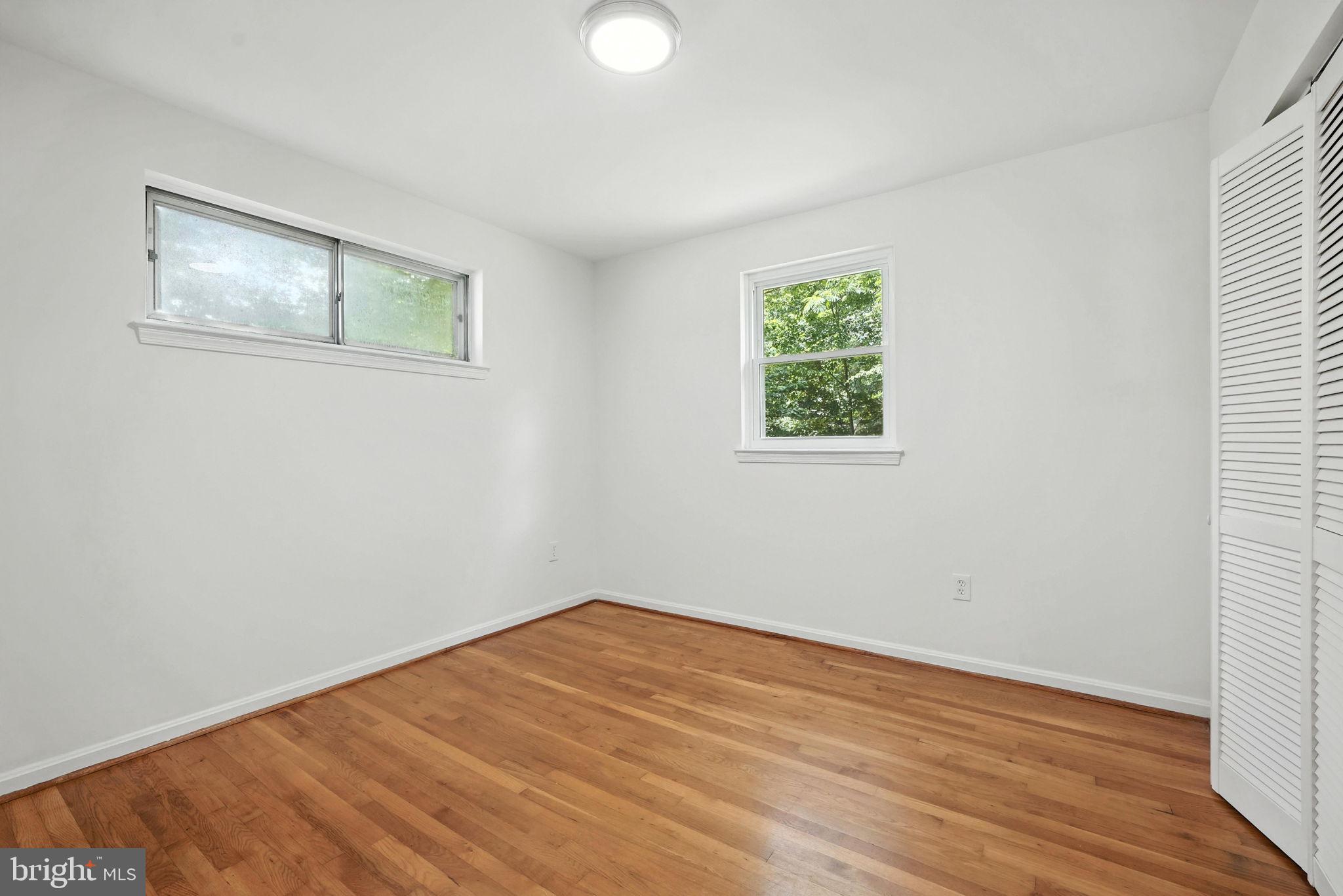 6910 Barnack Drive Springfield, VA 22152 - Photo 17 of 44 an empty room with wooden floor and windows