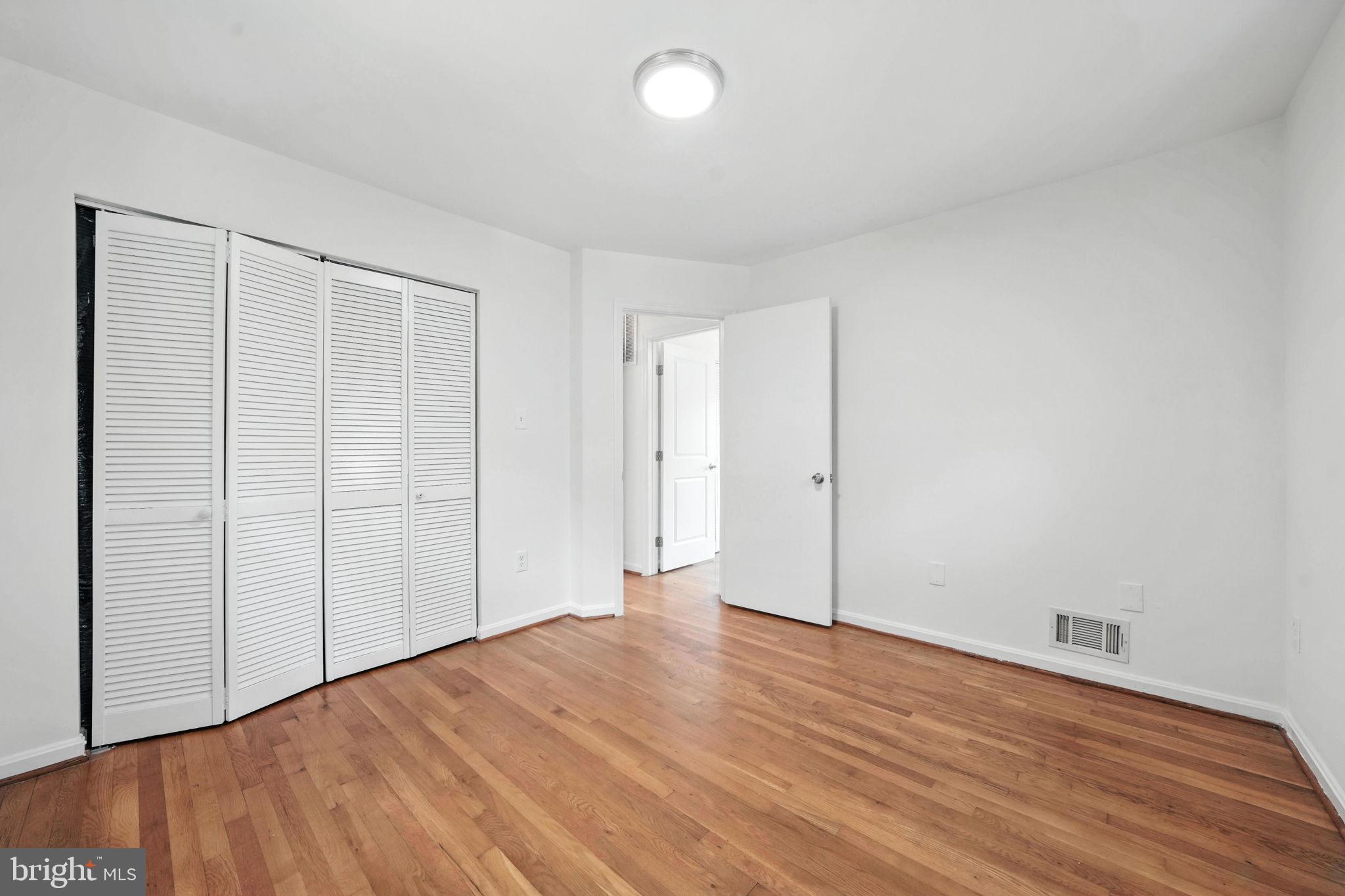 6910 Barnack Drive Springfield, VA 22152 - Photo 18 of 44 an empty room with wooden floor and closet