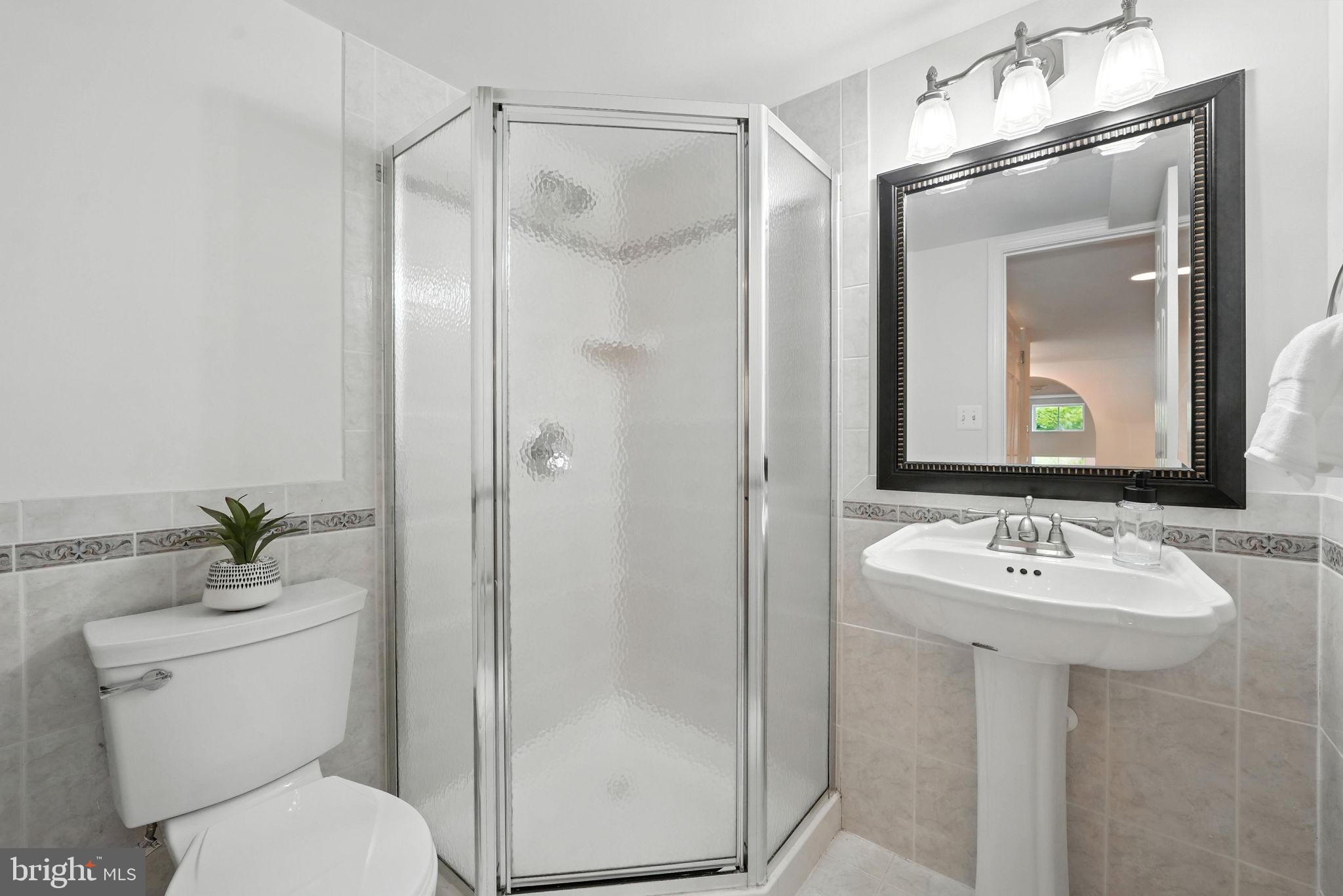 6910 Barnack Drive Springfield, VA 22152 - Photo 36 of 44 a bathroom with a toilet a sink and a mirror