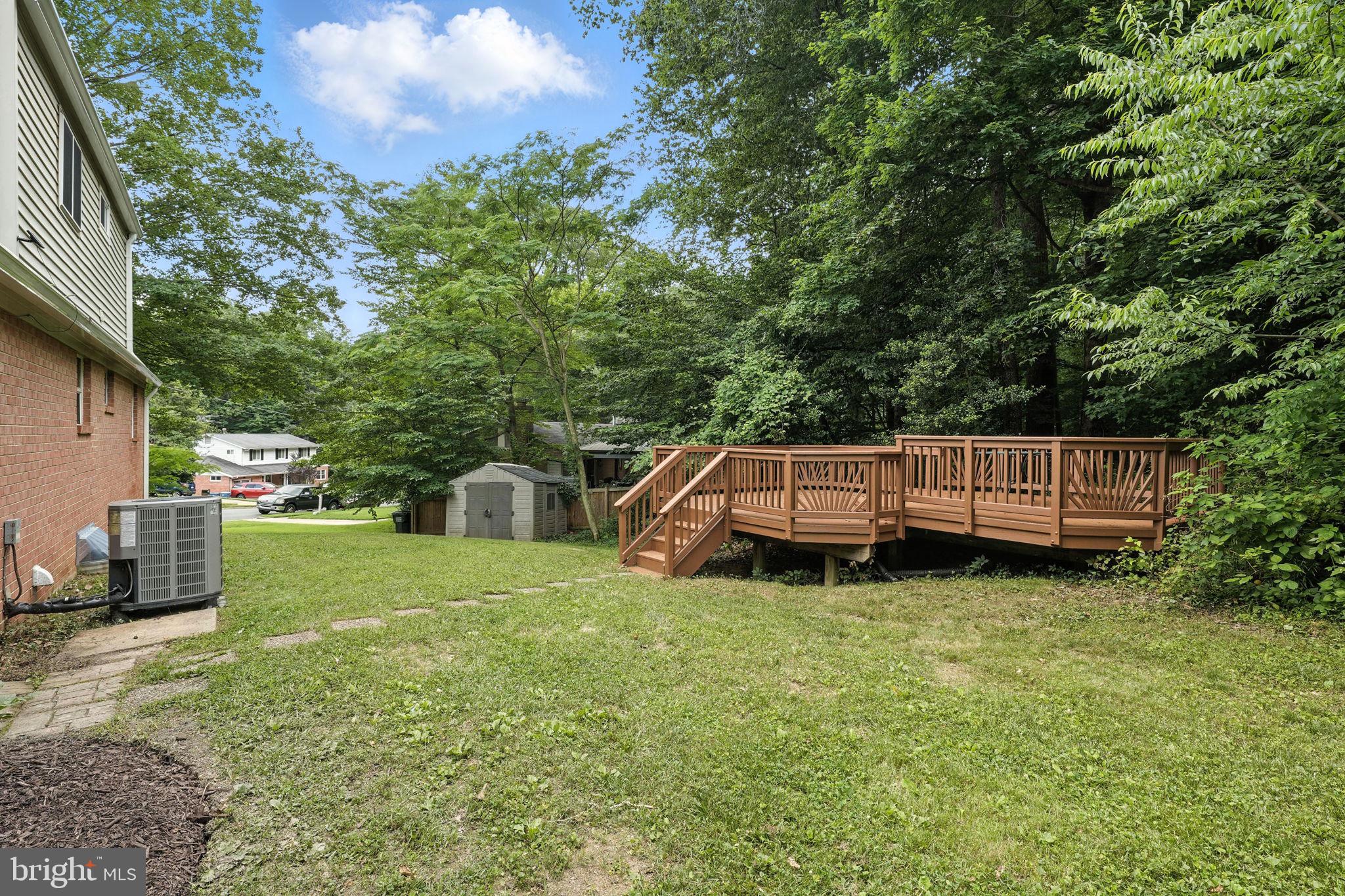 6910 Barnack Drive Springfield, VA 22152 - Photo 37 of 44 a backyard of a house with wooden fence and trees