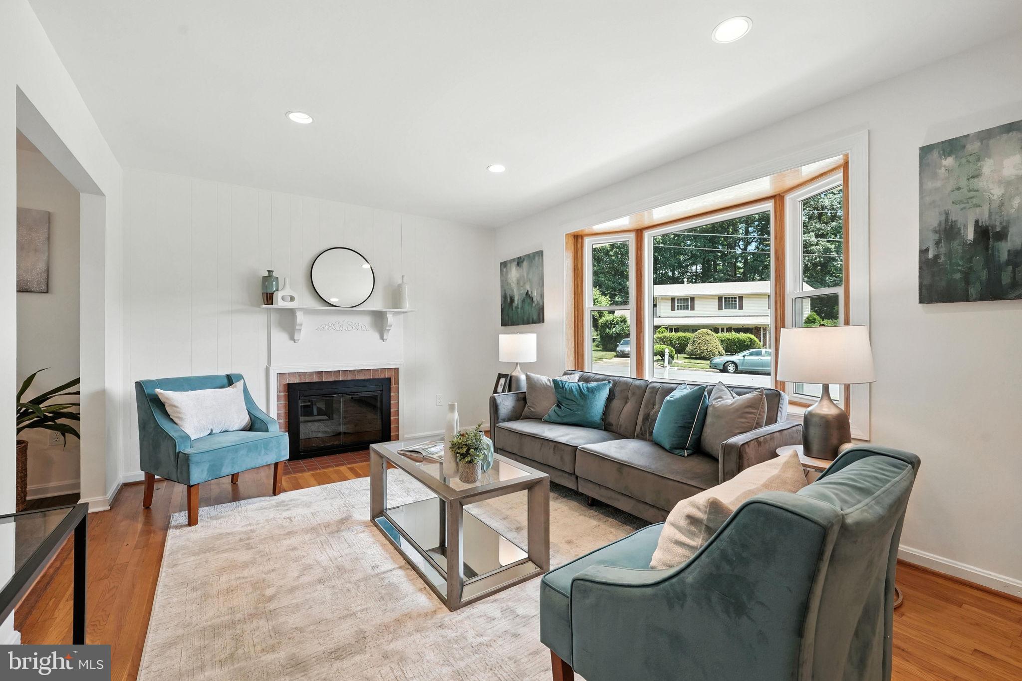 6910 Barnack Drive Springfield, VA 22152 - Photo 4 of 44 a living room with furniture a fireplace and a large window