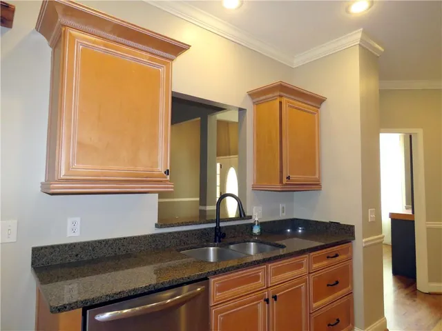 a kitchen sink with granite countertop a sink and a window