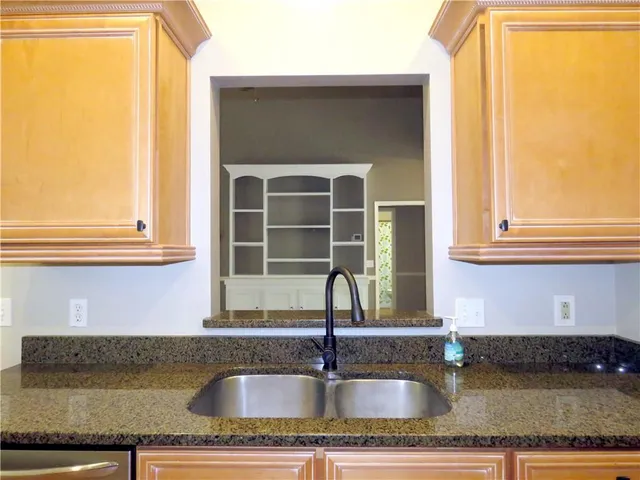 a kitchen with granite countertop a sink and a window