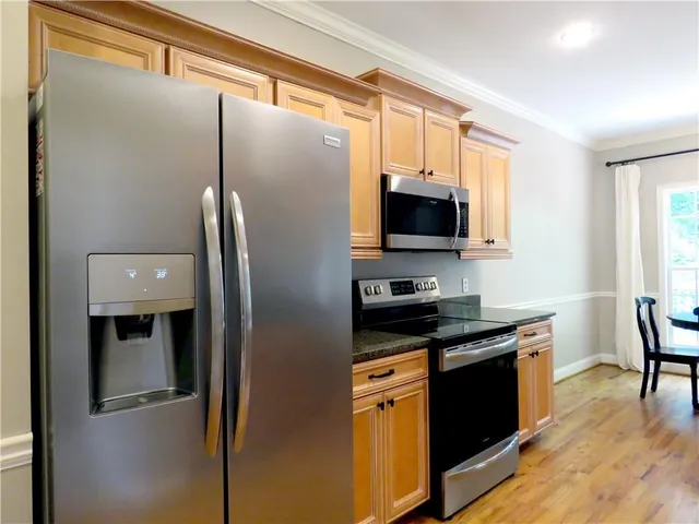 a kitchen with stainless steel appliances granite countertop a refrigerator and a stove top oven