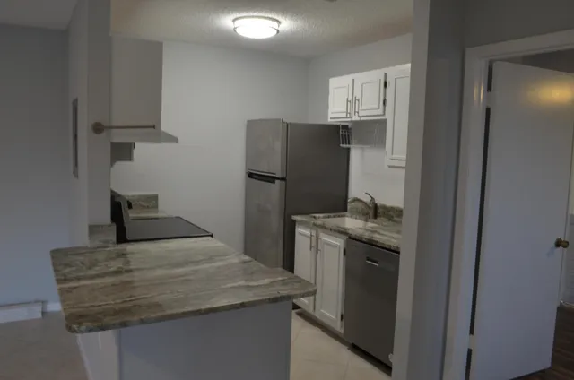 a kitchen with stainless steel appliances granite countertop a sink stove and cabinets