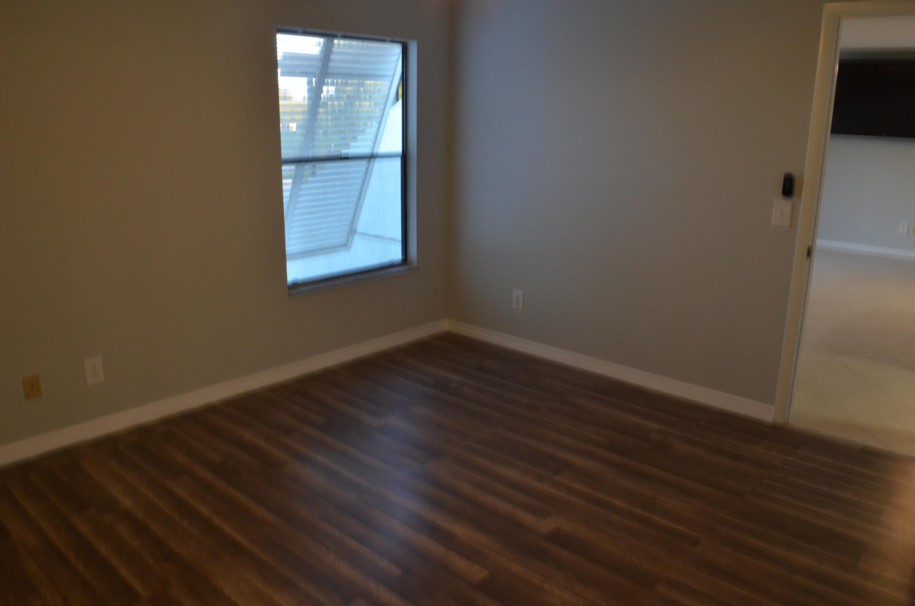 1212 Breezy Way, Unit 7H Sebastian, FL 32958 - Photo 10 of 26 a view of a small space with wooden floor and a window