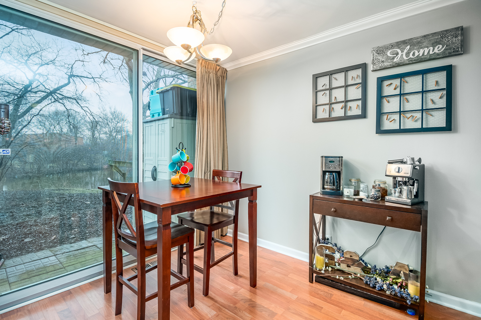 6015 Forest View Road, Unit 1A Lisle, IL 60532 - Photo 6 of 32 a dining room with wooden floor a chandelier a wooden table and chairs