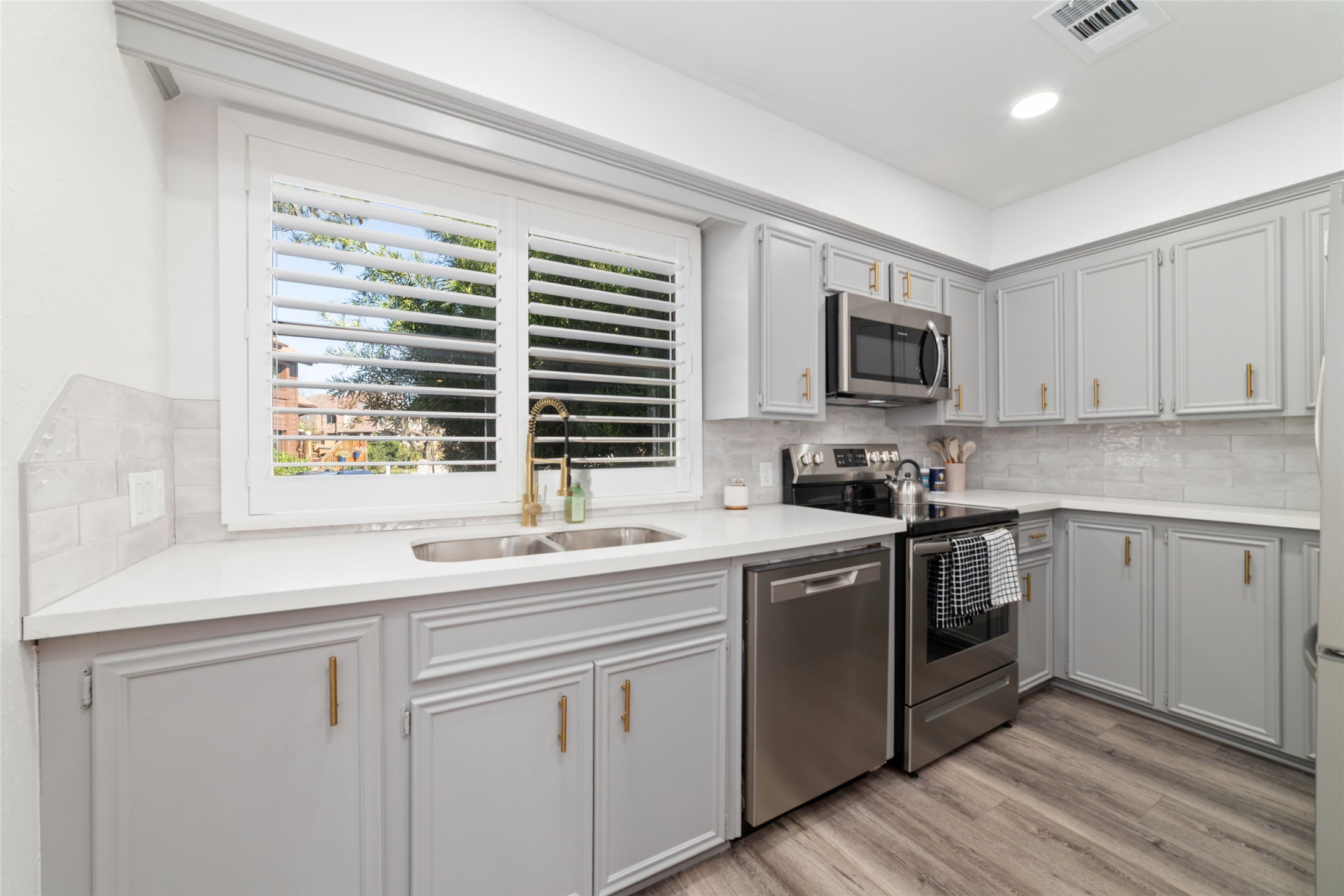 717 Davis Road League City, TX 77573 - Photo 7 of 32 a kitchen with cabinets stainless steel appliances a sink and a window