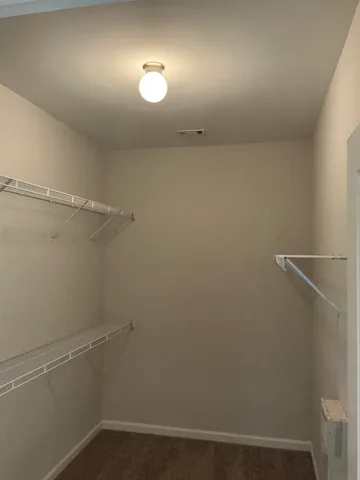 an empty room with wooden floor fireplace and windows