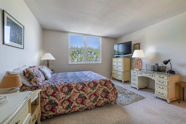 a bedroom with a bed and a tv on the dresser