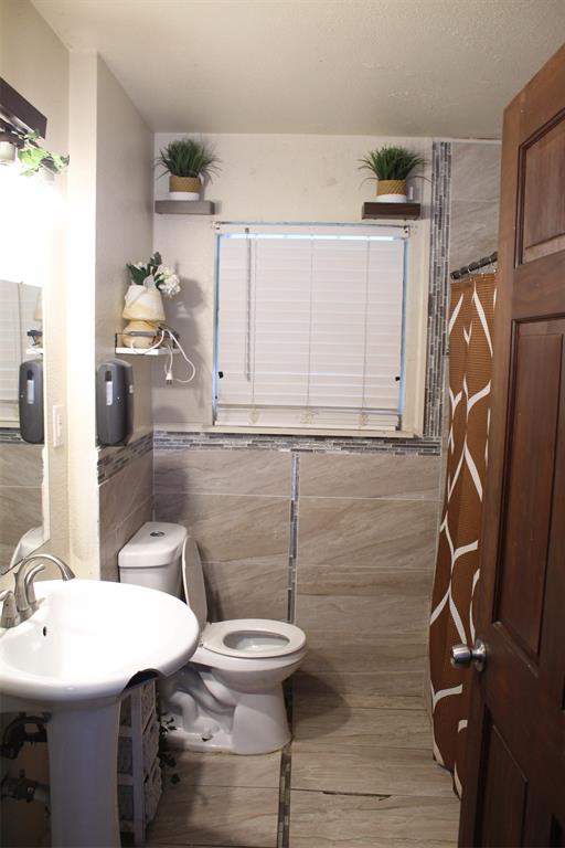 612 Ranier Circle Garland, TX 75041 - Photo 13 of 29 a bathroom with a sink a toilet and mirror