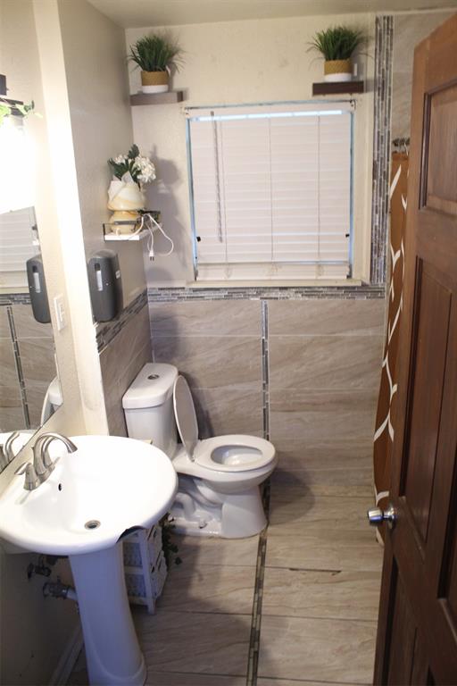 612 Ranier Circle Garland, TX 75041 - Photo 14 of 29 a bathroom with a sink a toilet and a mirror