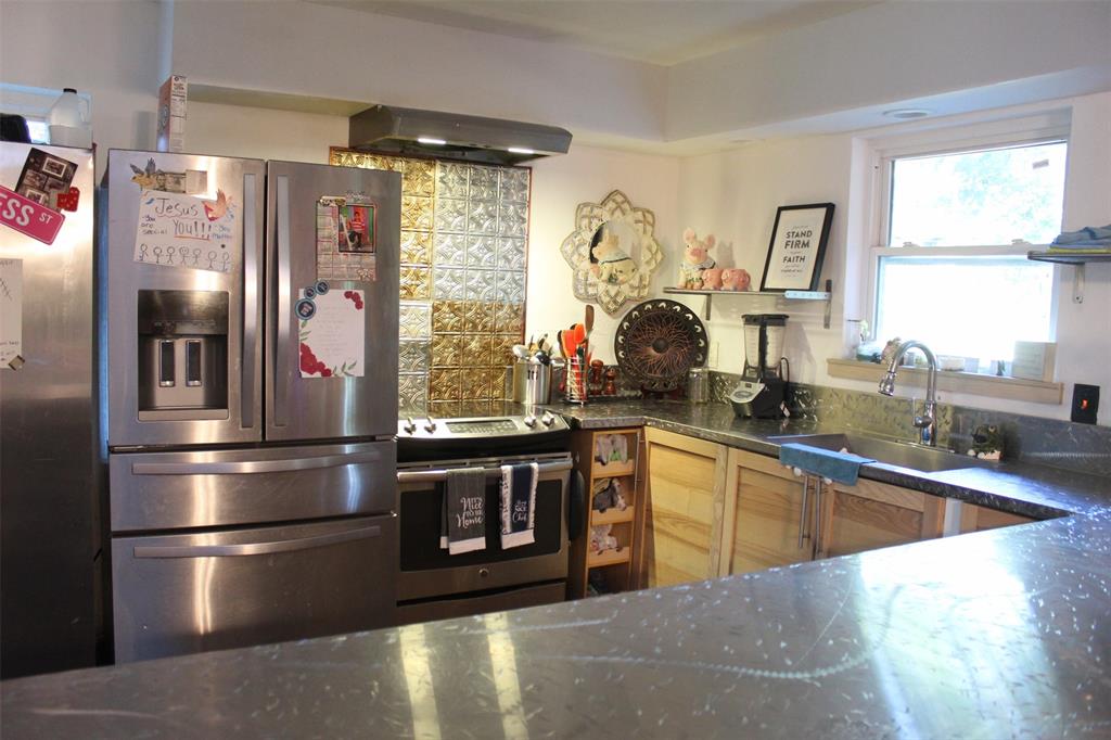 612 Ranier Circle Garland, TX 75041 - Photo 16 of 29 a kitchen with stainless steel appliances kitchen island granite countertop a refrigerator a sink a stove and white cabinets with wooden floor