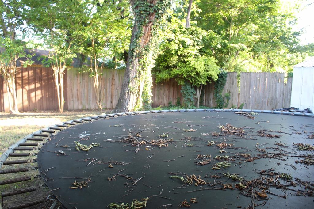 612 Ranier Circle Garland, TX 75041 - Photo 25 of 29 a backyard of a house with large trees and wooden fence