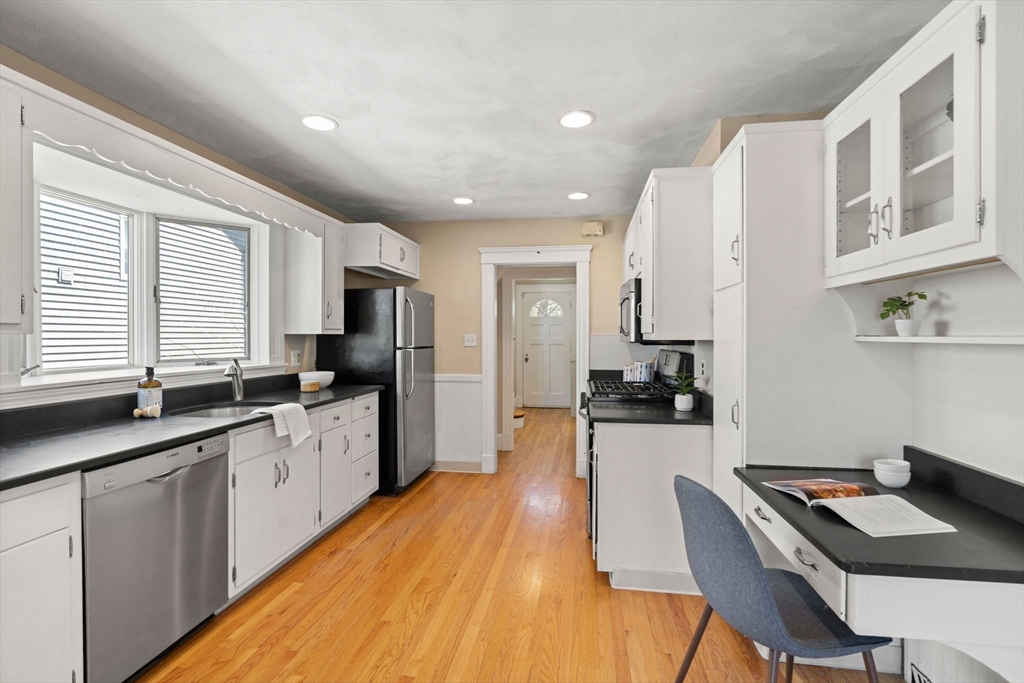 156 Russett Road Boston, MA 02132 - Photo 16 of 32 a kitchen with granite countertop a sink stove and refrigerator