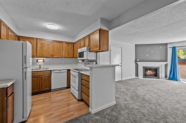 a kitchen with granite countertop a refrigerator stove top oven and sink