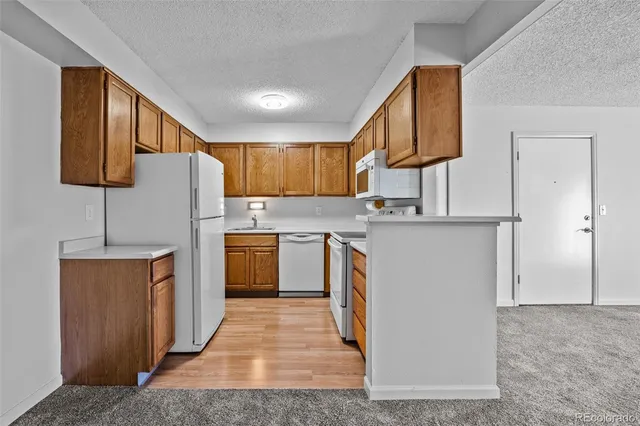 a kitchen with cabinets a sink and white appliances