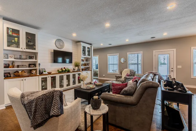 a living room with furniture a flat screen tv and a window