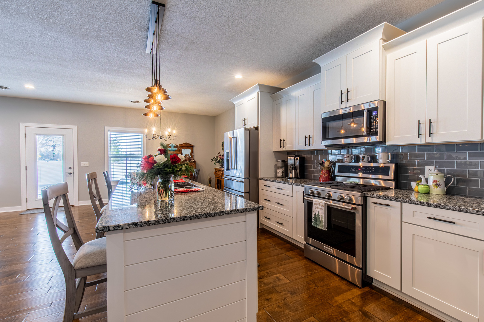 825 East Thompson Street Princeton, IL 61356 - Photo 6 of 26 a kitchen with stainless steel appliances granite countertop a stove top oven a sink dishwasher a dining table and chairs with wooden floor