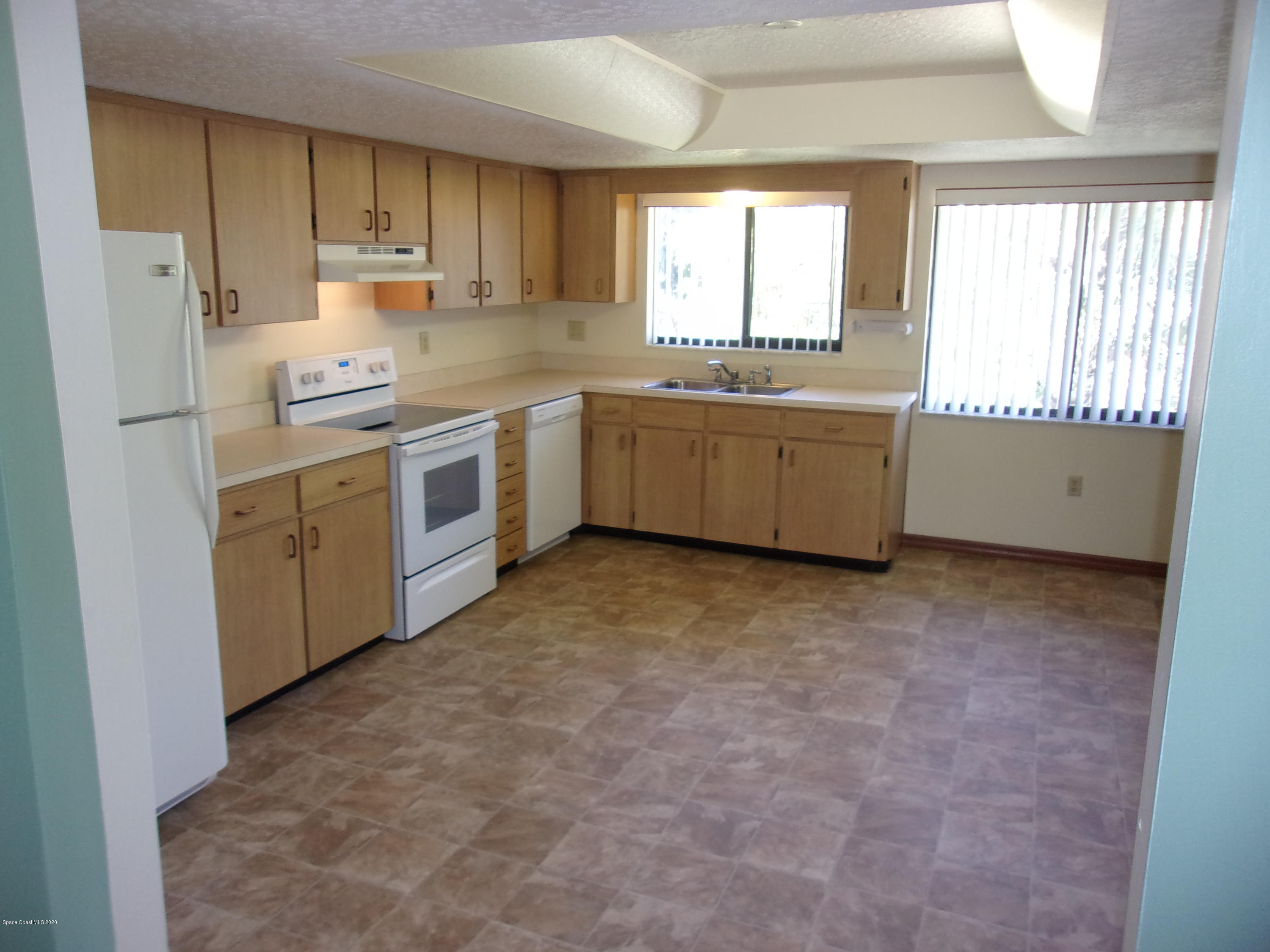 418 South Atlantic Avenue, Unit 3 Cocoa Beach, FL 32931 - Photo 11 of 29 a kitchen with a white cabinets and white appliances