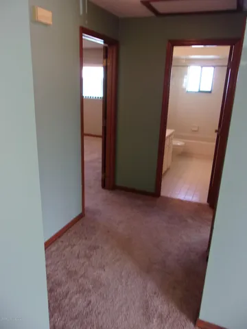 an empty room with windows and chandelier fan