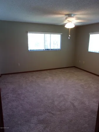 an empty room with windows cabinet and front door