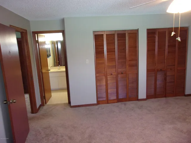 an empty room with closet and chandelier fan
