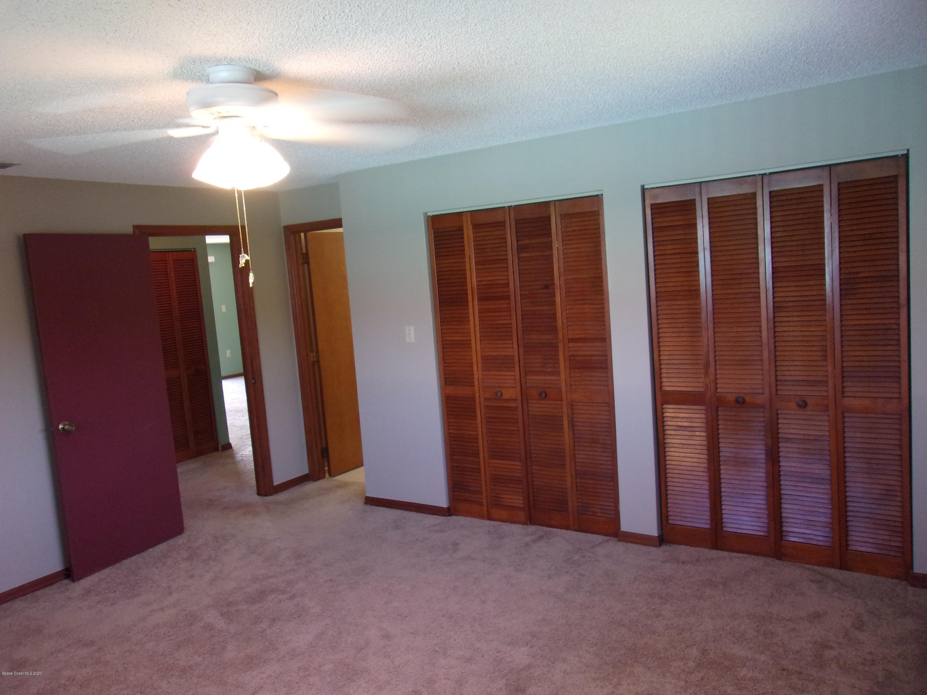 418 South Atlantic Avenue, Unit 3 Cocoa Beach, FL 32931 - Photo 18 of 29 an empty room with closet and chandelier fan