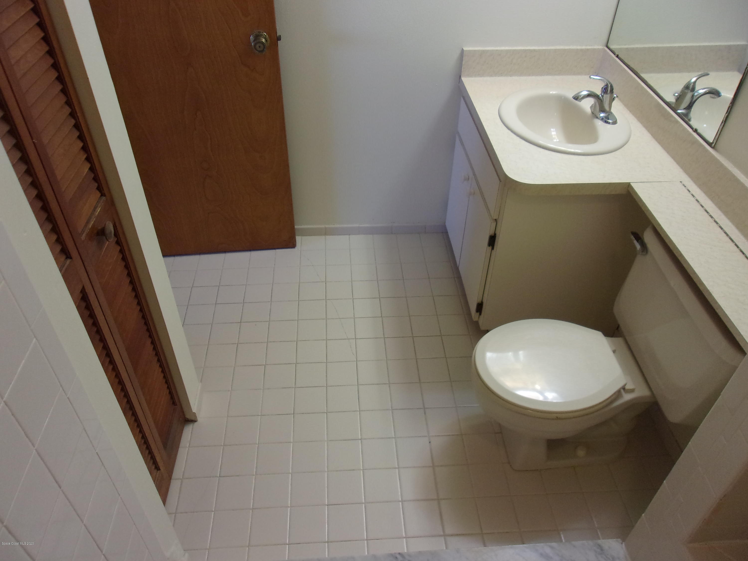 418 South Atlantic Avenue, Unit 3 Cocoa Beach, FL 32931 - Photo 21 of 29 a bathroom with a sink a toilet and a mirror