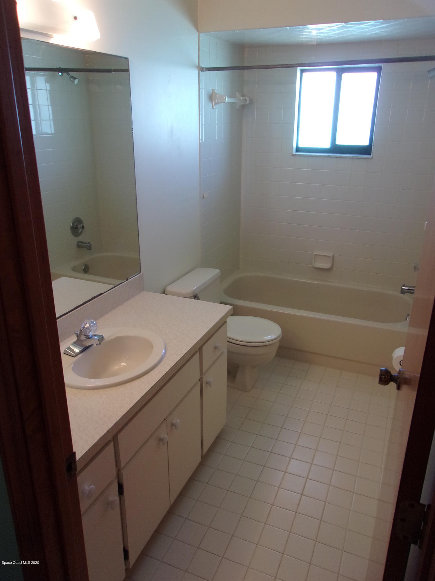 418 South Atlantic Avenue, Unit 3 Cocoa Beach, FL 32931 - Photo 23 of 29 a bathroom with a sink a toilet and shower